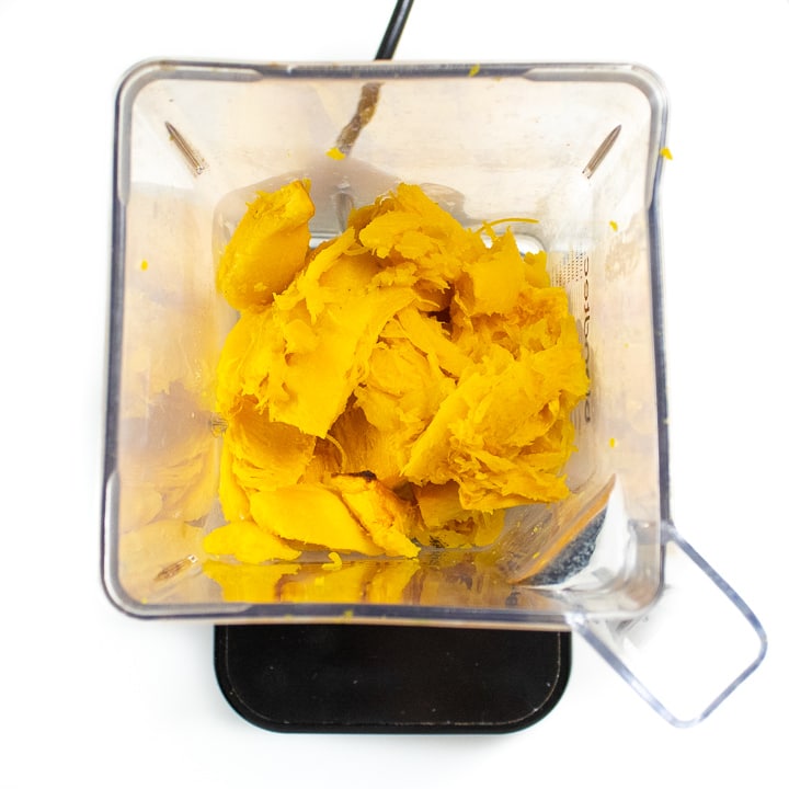Chunks of roasted pumpkin in a blender.