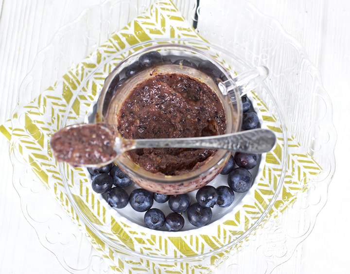 Image is of a clear cup with the chunky puree inside, with a spoon resting on top of the lid.