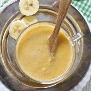Bowls scattered on white board with homemade baby food puree.