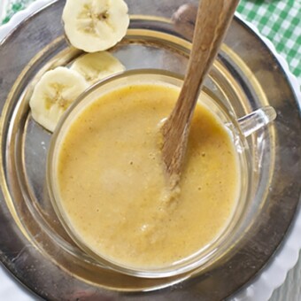 Bowls scattered on white board with homemade baby food puree.