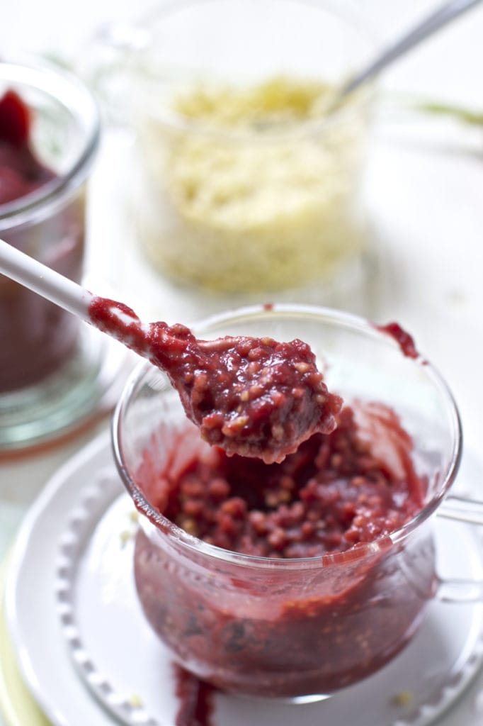 Glass jar filled with carrot, cherry and millet baby food puree.