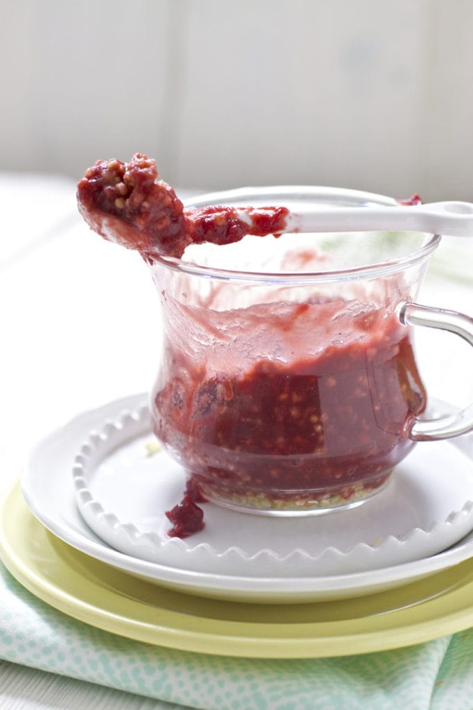 Glass jar filled with carrot, cherry and millet baby food puree.