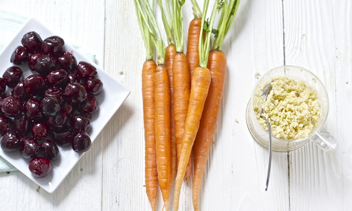 Carrots in a bunch on a wooden table.