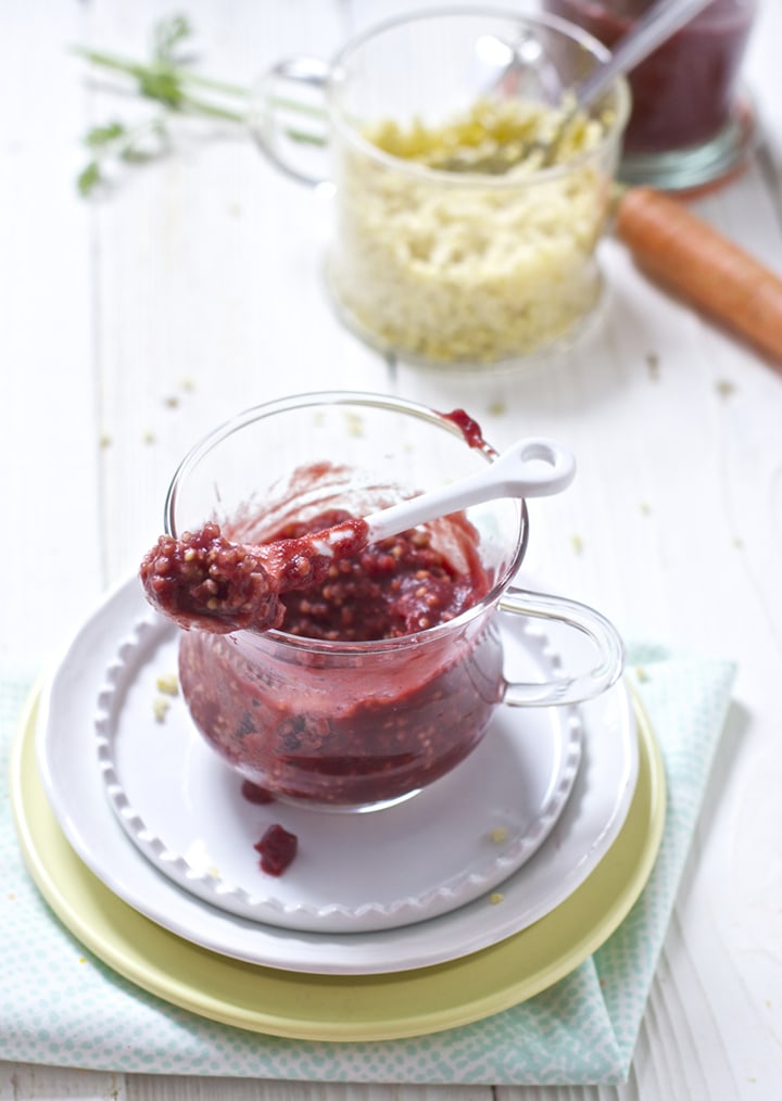 Glass jar filled with carrot, cherry and millet baby food puree.