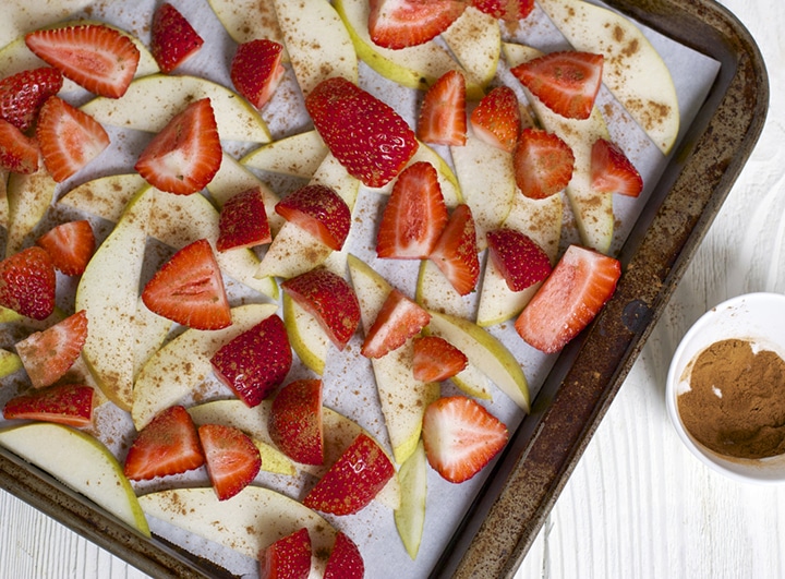 Strawberries and pears on a baking sheet.