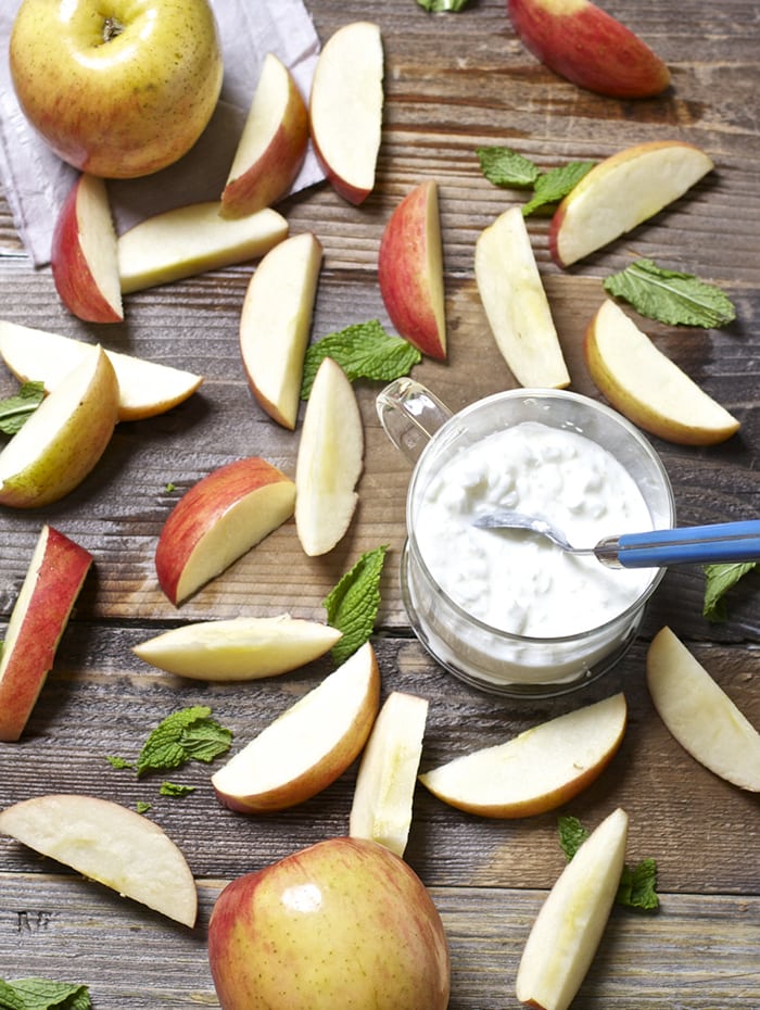 Spread on a wooden board with a clear jar of cottage cheese and mint leaves.