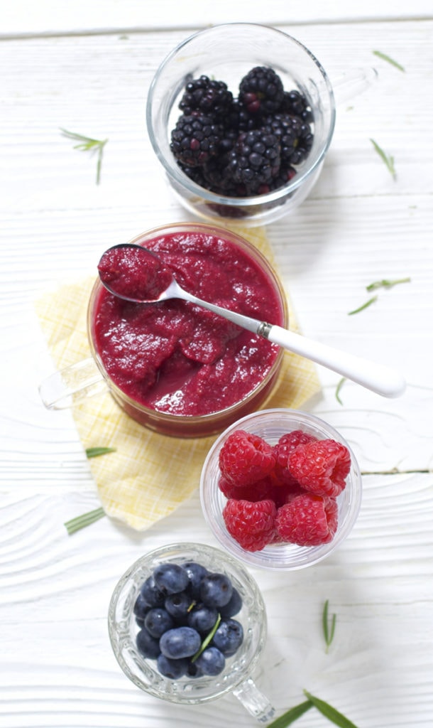 Spread of glass bowls filled with produce and a homemade baby food puree.