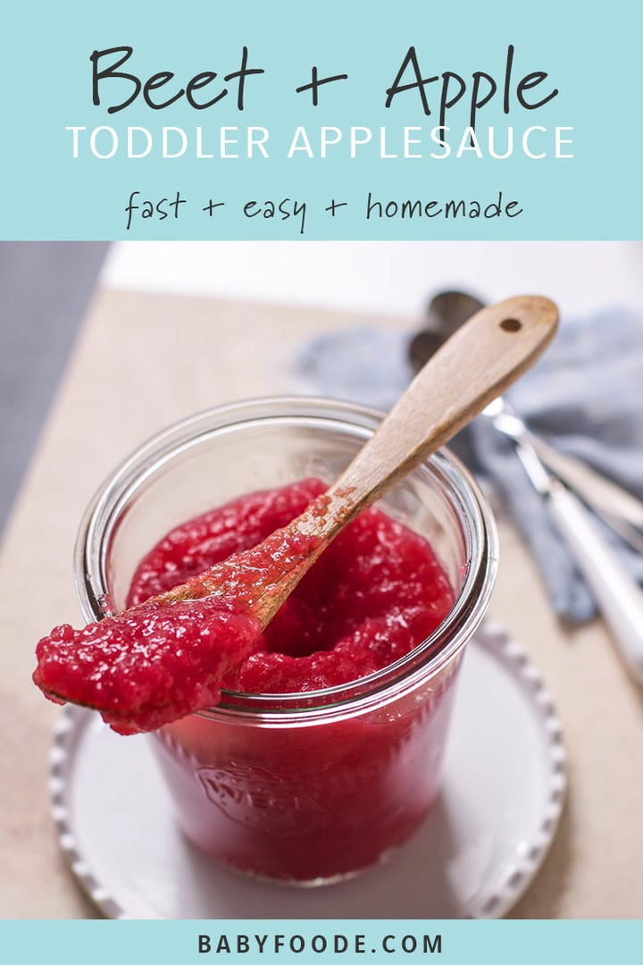 A glass jar of red beet applesauce with a small wood spoon.