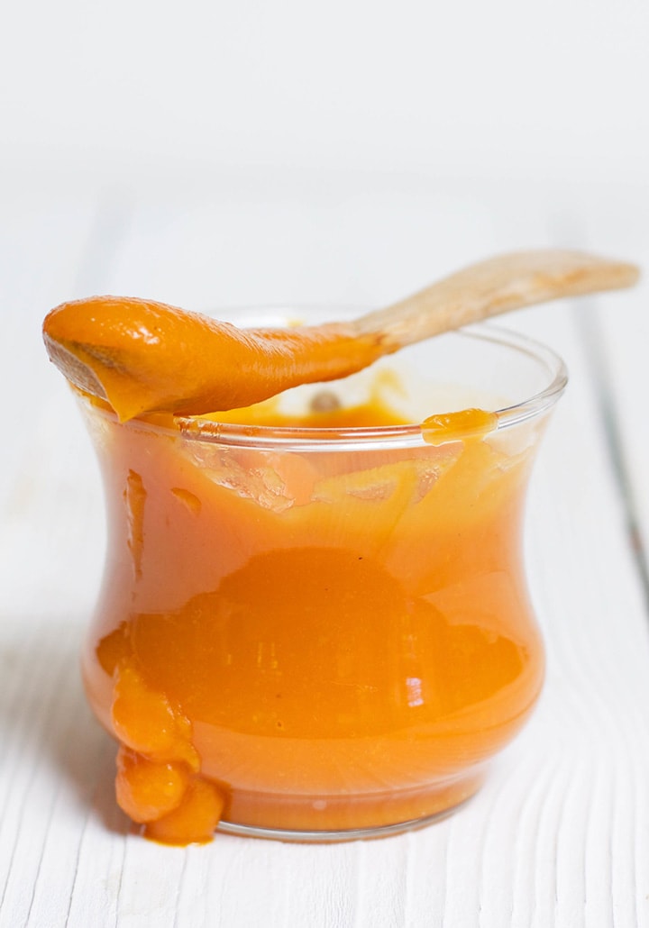 Image is of a glass bowl filled with smooth baby food puree.