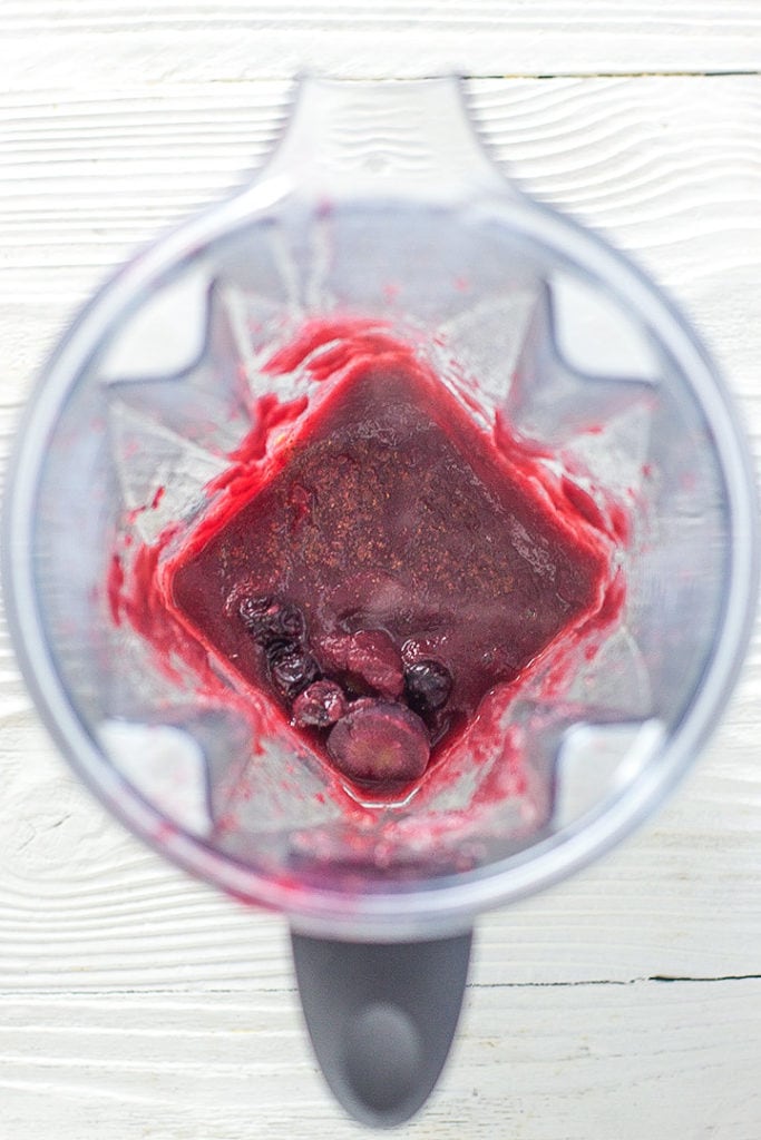 Blender filled with purple baby food puree.