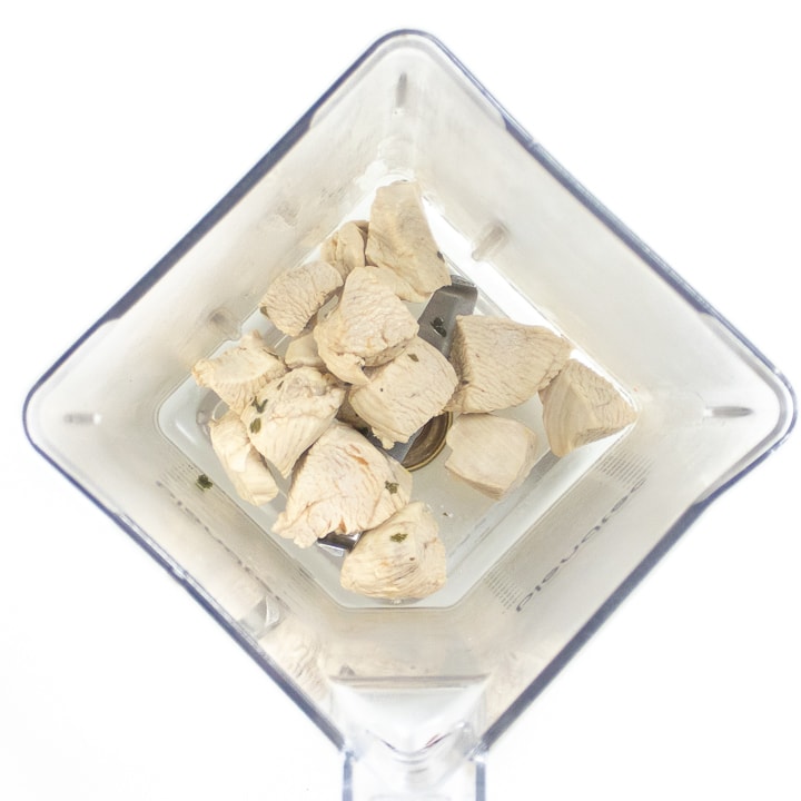 Blender full of cooked chicken for baby food puree.