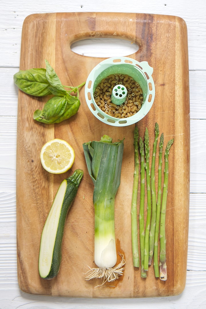 cutting board with fresh green veggies on top.