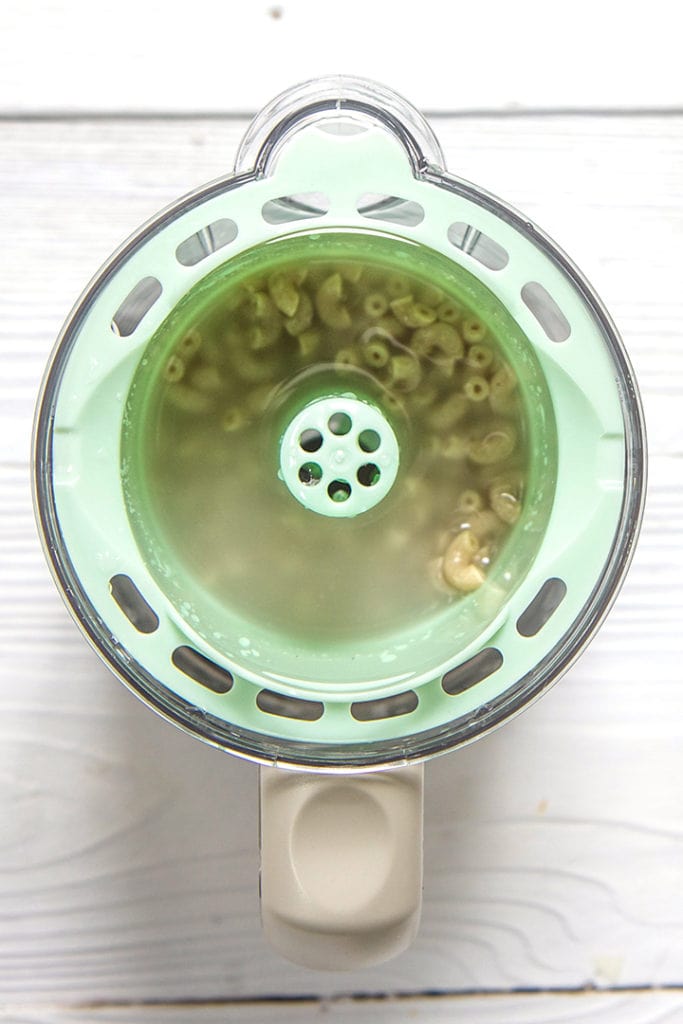 steamer basket with water and dried pasta inside.