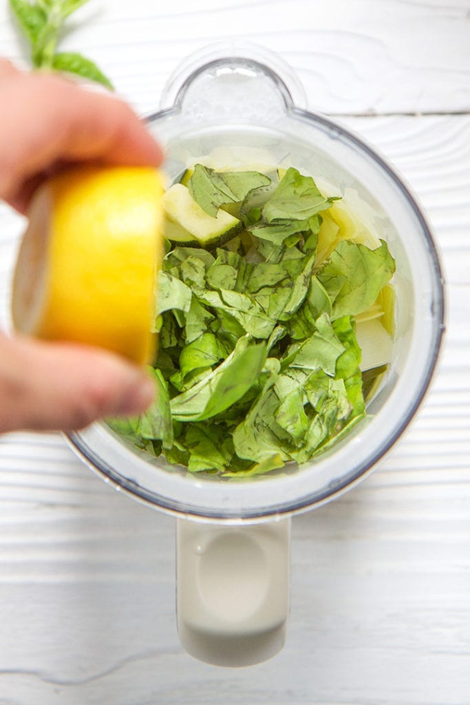 steamer basket with a hand squeezing lemon inside.