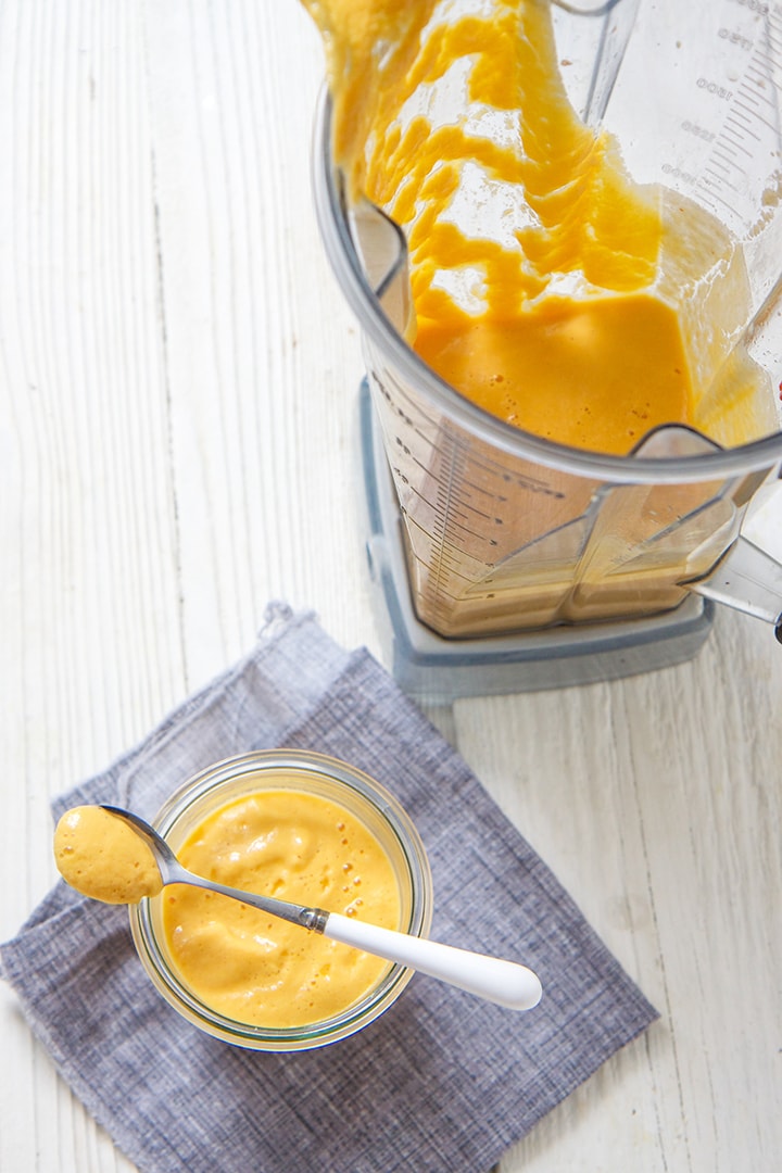 Blender and a small bowl filled with Thai chicken baby food puree.