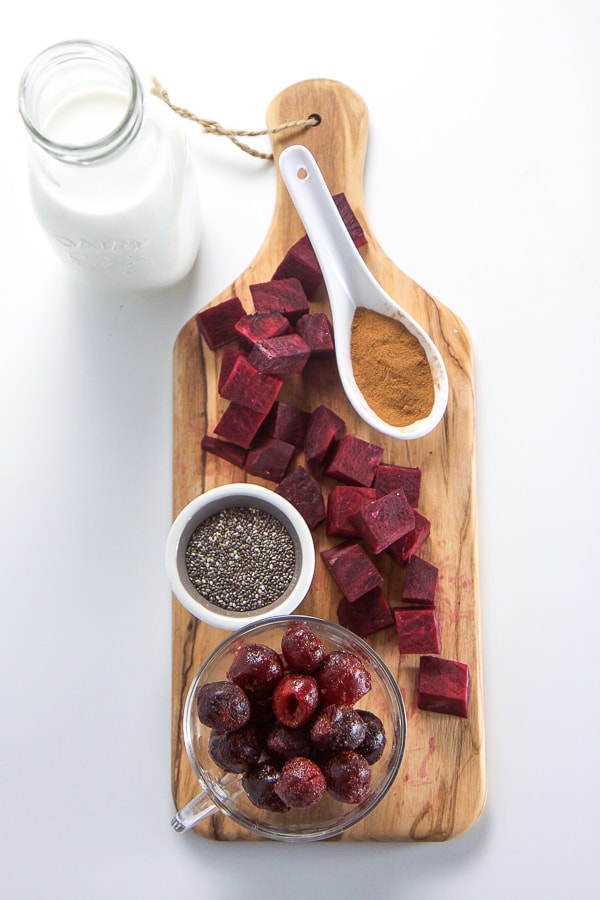 Ingredients for a cherry beet smoothie arranged on a white background.