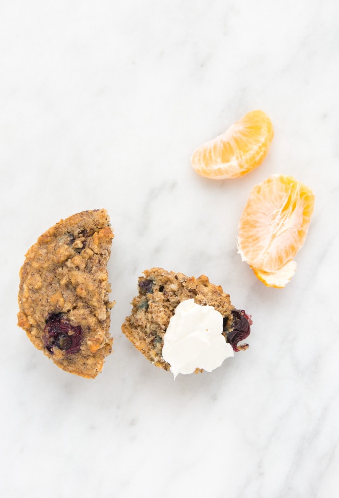 Blueberry oatmeal muffins with orange slices on marble counter