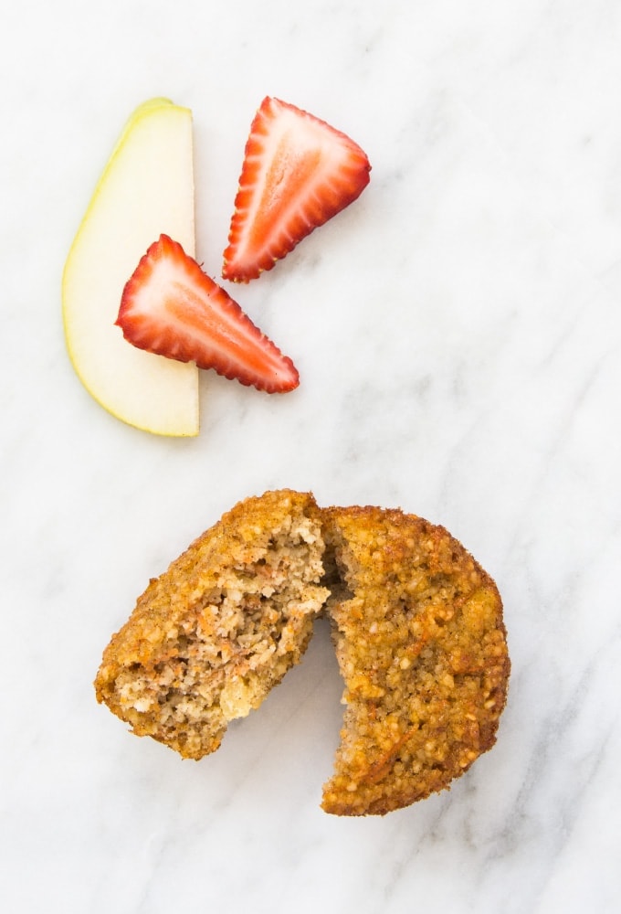 Muffin with apple slice and strawberries on marble counter
