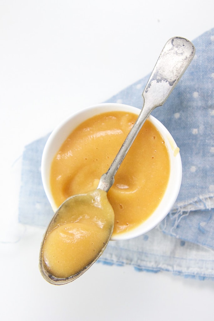 Small white bowl filled with a peach and cauliflower baby food puree.