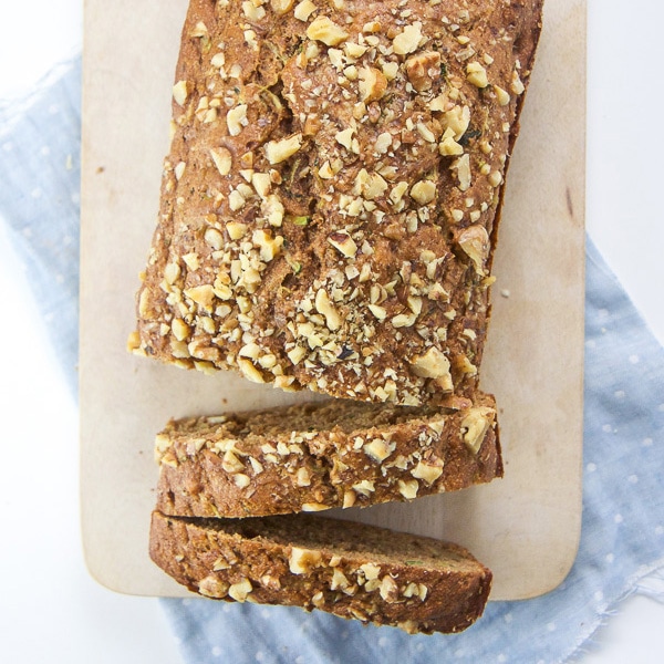Healthy sugar free zucchini bread on a cutting board with two slices cut.
