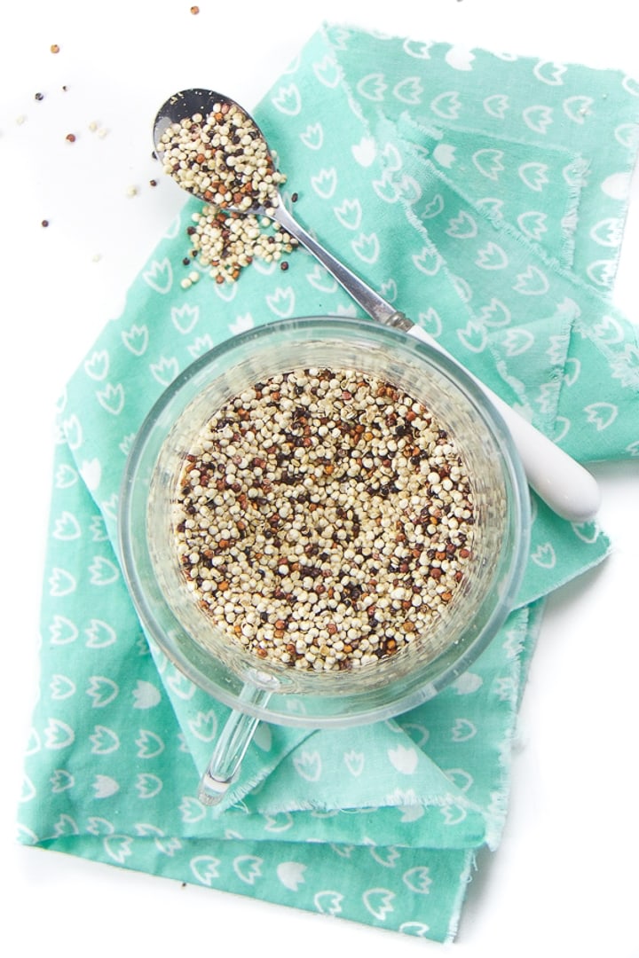 Small glass bowl with dried quinoa inside.