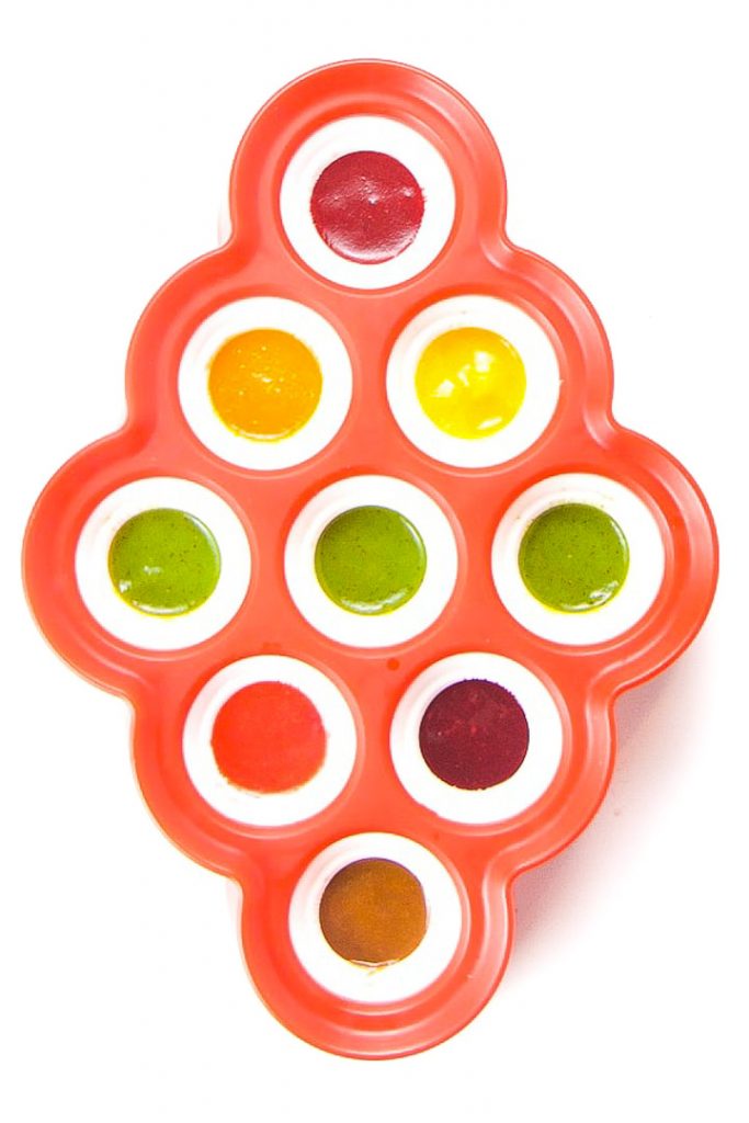 Red mini popsicle mold filled with different colors of popsicles.