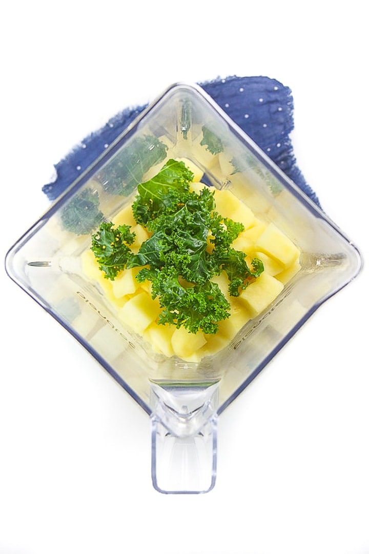 blender full of cooked apple and kale for baby food.