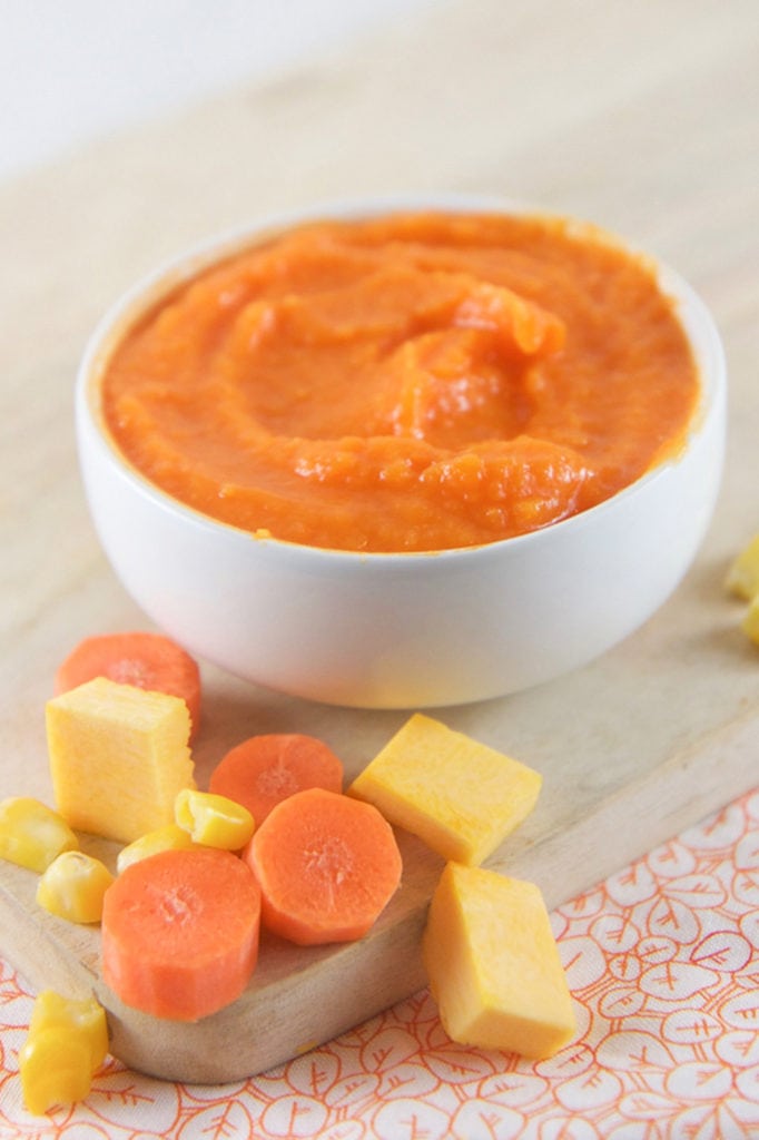 A small white bowl filled with a carrot pumpkin baby food puree.