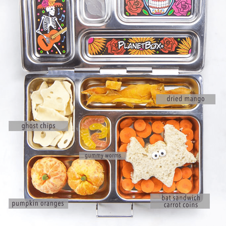 Image is of an open lunch box with healthy halloween themed food inside with everything labeled.