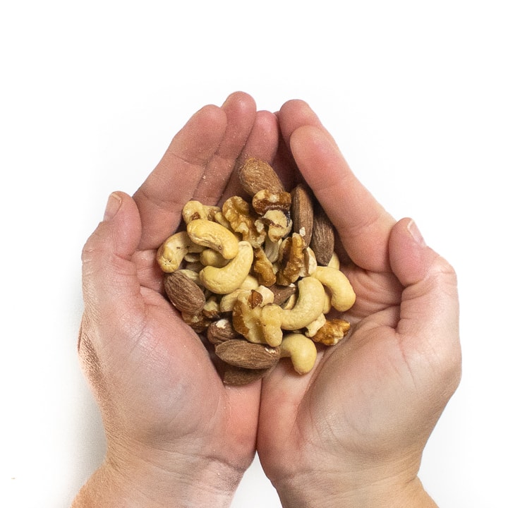 Hands holding a Buch of nuts.