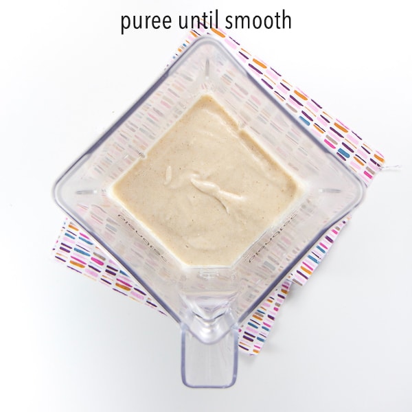 homemade baby cereal - blender with the grains pureed and turned into a smooth puree for baby. Text on photo says - puree until smooth
