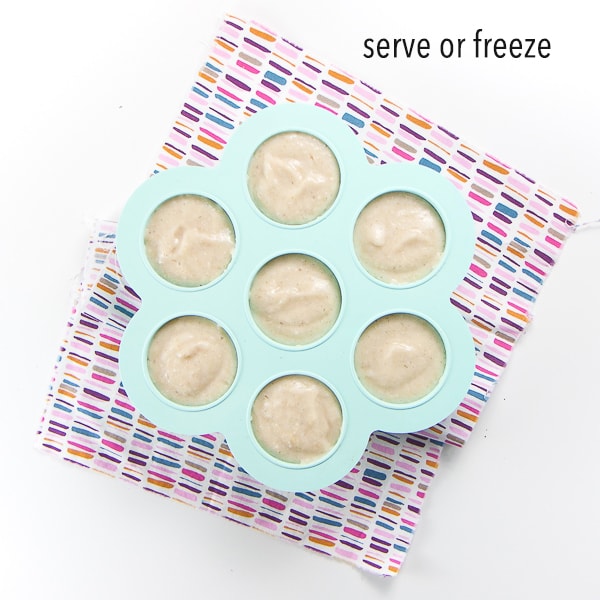 homemade baby cereal has been pureed and poured into a 7 section container getting ready for the freezer. Text on photo reads - serve or freeze