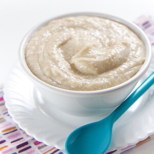 white bowl filled with a homemade baby cereal of rice, oats and barley and probiotics
