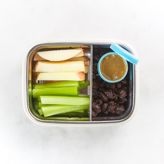Rectangle kids bento box - cut up apples and celery, small blue container with peanut butter and some raisins