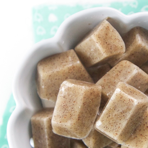 A white bowl filled with frozen cubes of quinoa baby cereal - 4 months and up