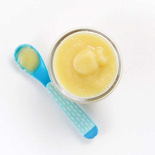 A small class jar is filled with a creamy apple and cinnamon puree.