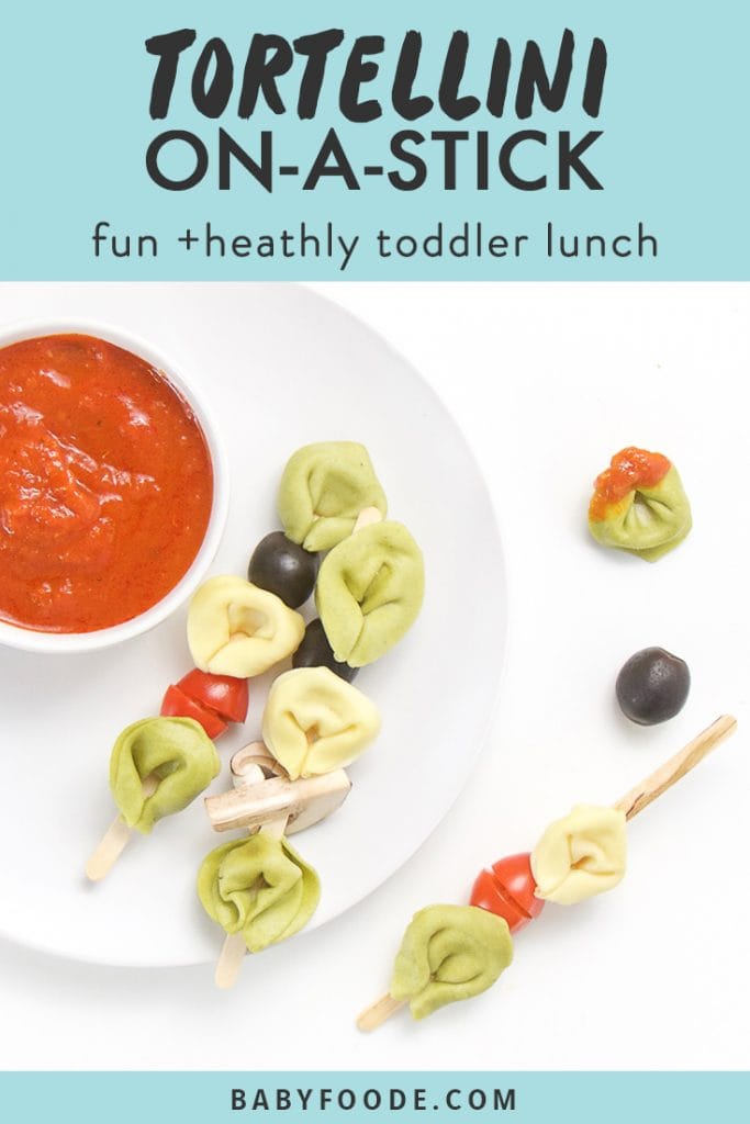 graphic for post- text reads tortellini on-a-stick, fun and healthy toddler lunch. image is of small white plate sitting on a white surface. On top of plate is a small white bowl filled with a dipping sauce and 3 wooden sticks filled with tortellini and veggies, a couple of tortellini and veggies are scattered on the table.