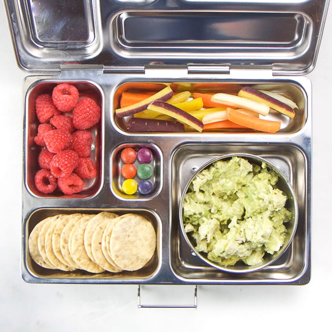 silver planet box filled with avocado chicken salad, carrots, raspberries, crackers and candy for a great allergy-free school lunch box for kids.