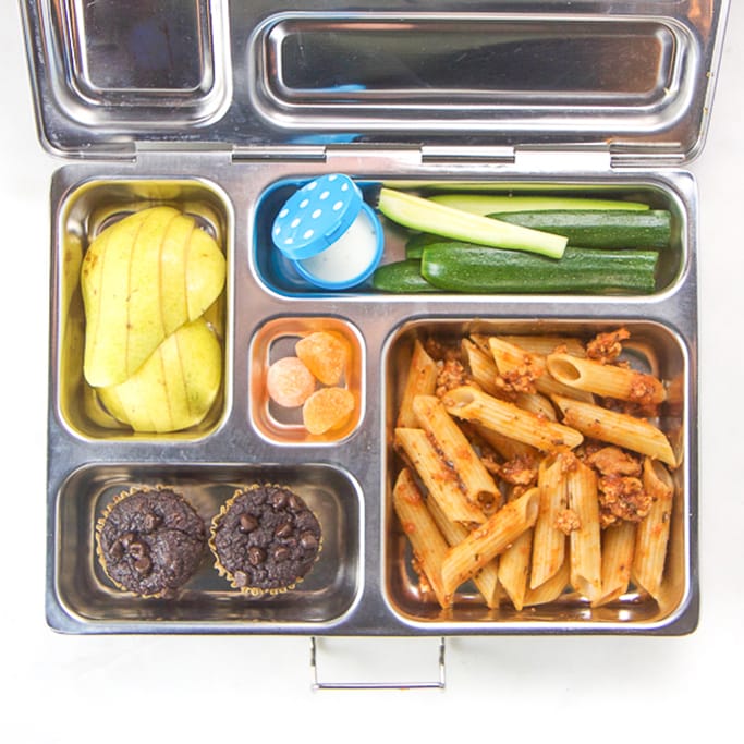 silver planet box filled with pasta, chocolate allergy-free muffins, zucchini sticks, pear and candy.