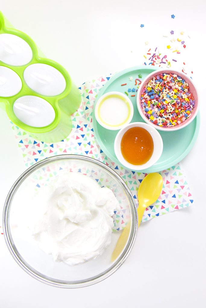 Everything you need to make healthy funfetti popsicles - yogurt, honey, milk, sprinkles and popsicle molds.