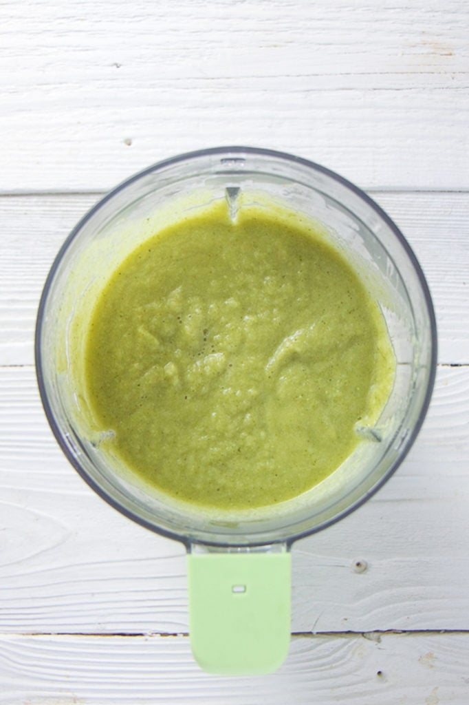 A blender with broccoli asparagus baby food puree.