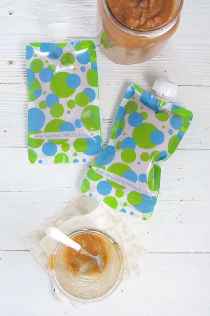 A couple of reusable pouches with an empty jar of carrot applesauce next to it.