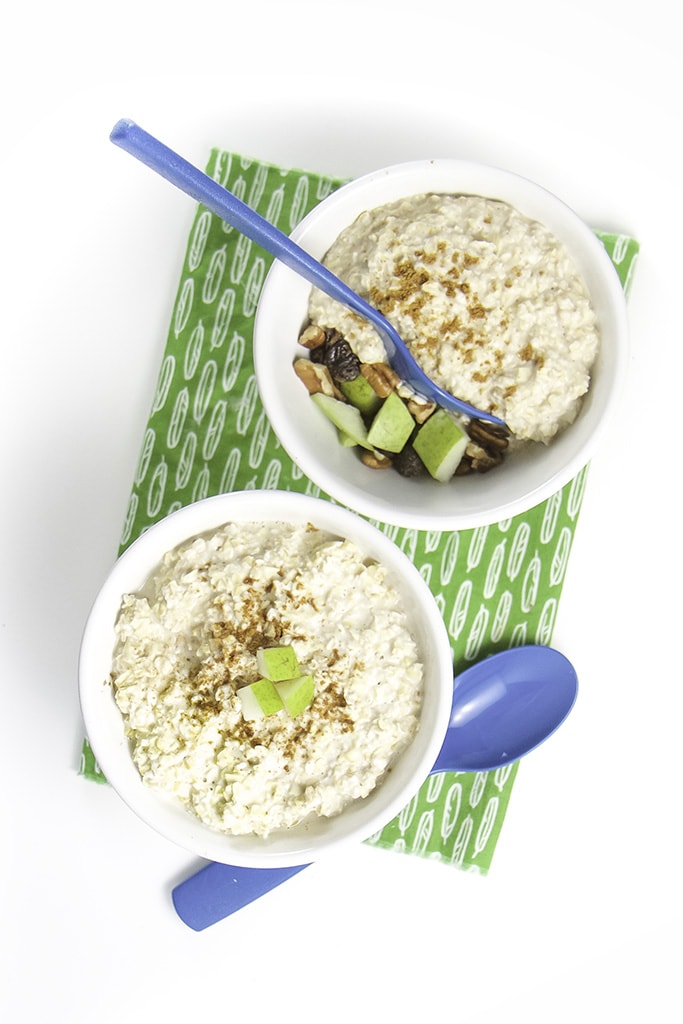 two bowls filled with oatmeal and one showing the toppings below the oats.