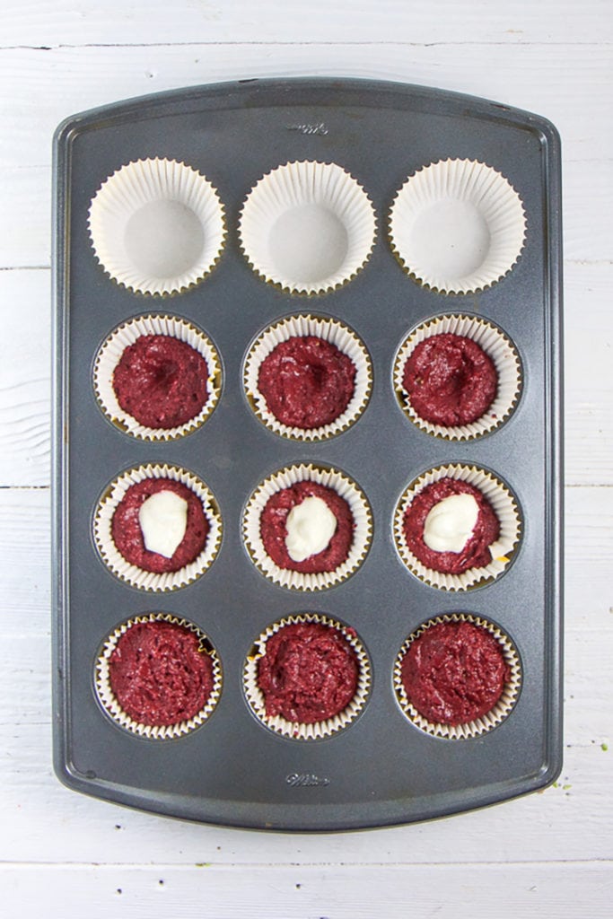 Muffin tray gettin full up of healthy beet chocolate muffins.