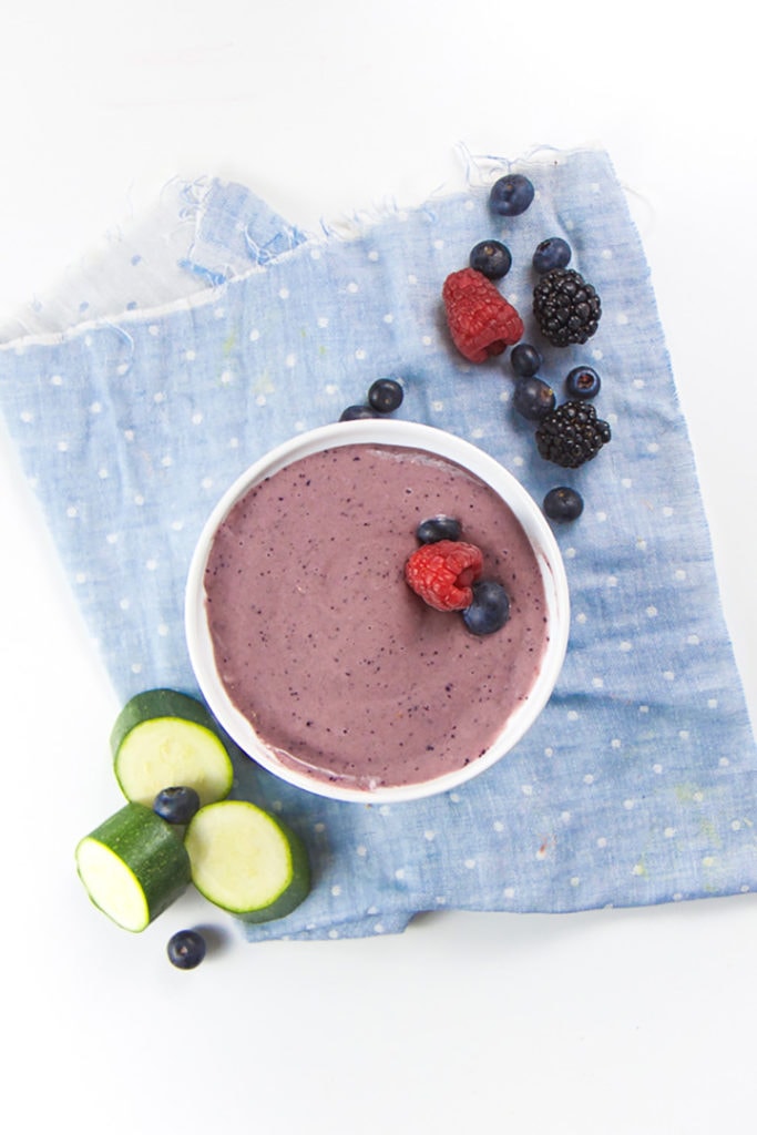 Bowl of purple baby breakfast cereal surrounded by produce.
