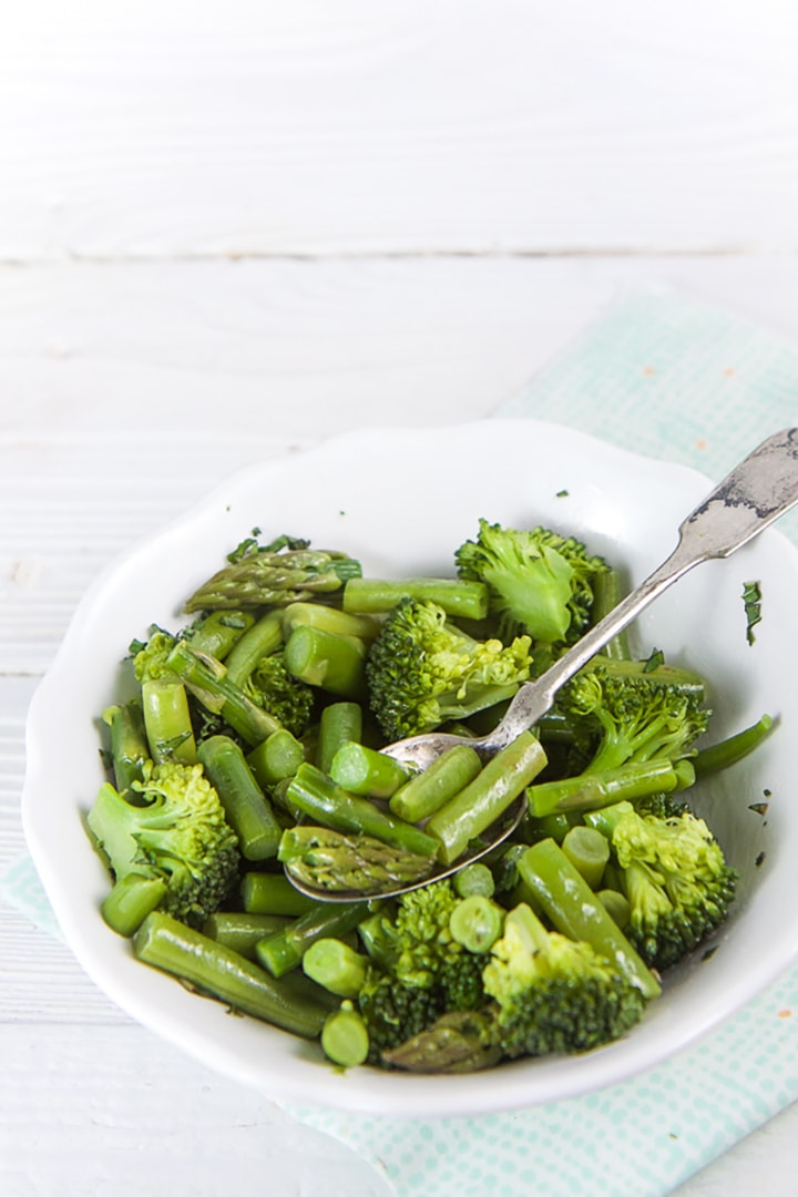 White bowl filled with green veggies for finger foods or baby-led weaning.