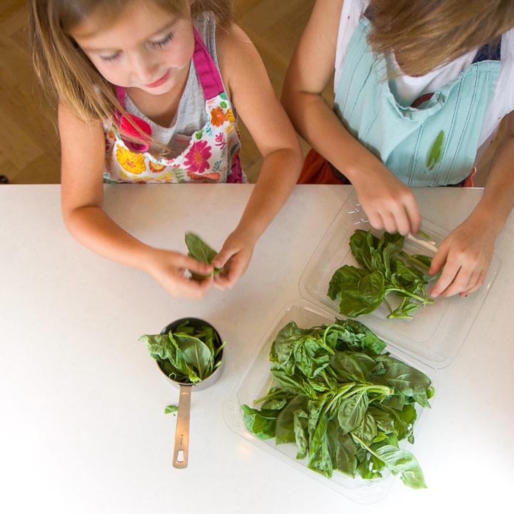 2 girls standing at a counter working on a recipe.
