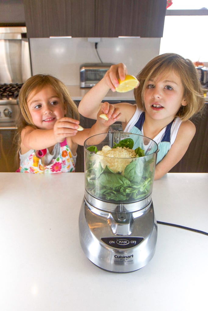 2 girls place items into a food processor - cooking with kids.