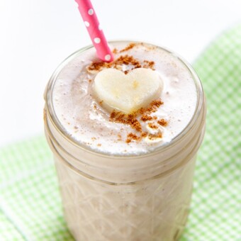 Glass full of toddler and kid approved smoothie with a pink straw and heart shaped apple.