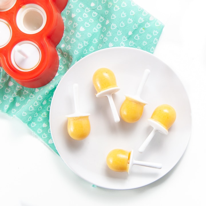 Plate filled with orange vitamin c popsicles.